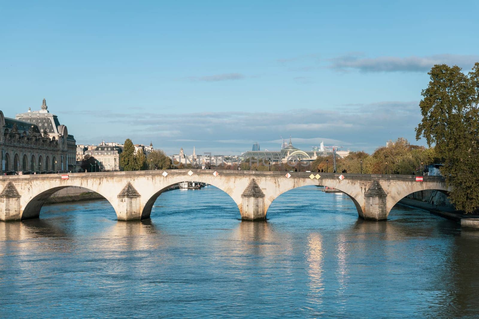 There is an impressive bridge spanning a tranquil body of water, with various buildings visible in the background, Paris, France - October 24, 2024