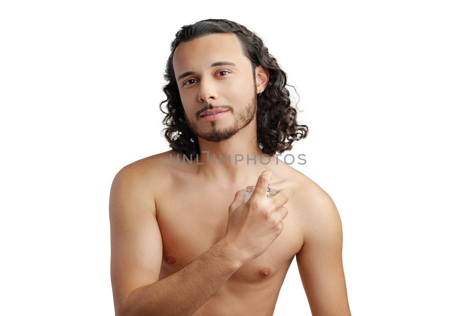 A young man with curly hair applying fragrance after a shower while smiling at the camera close up