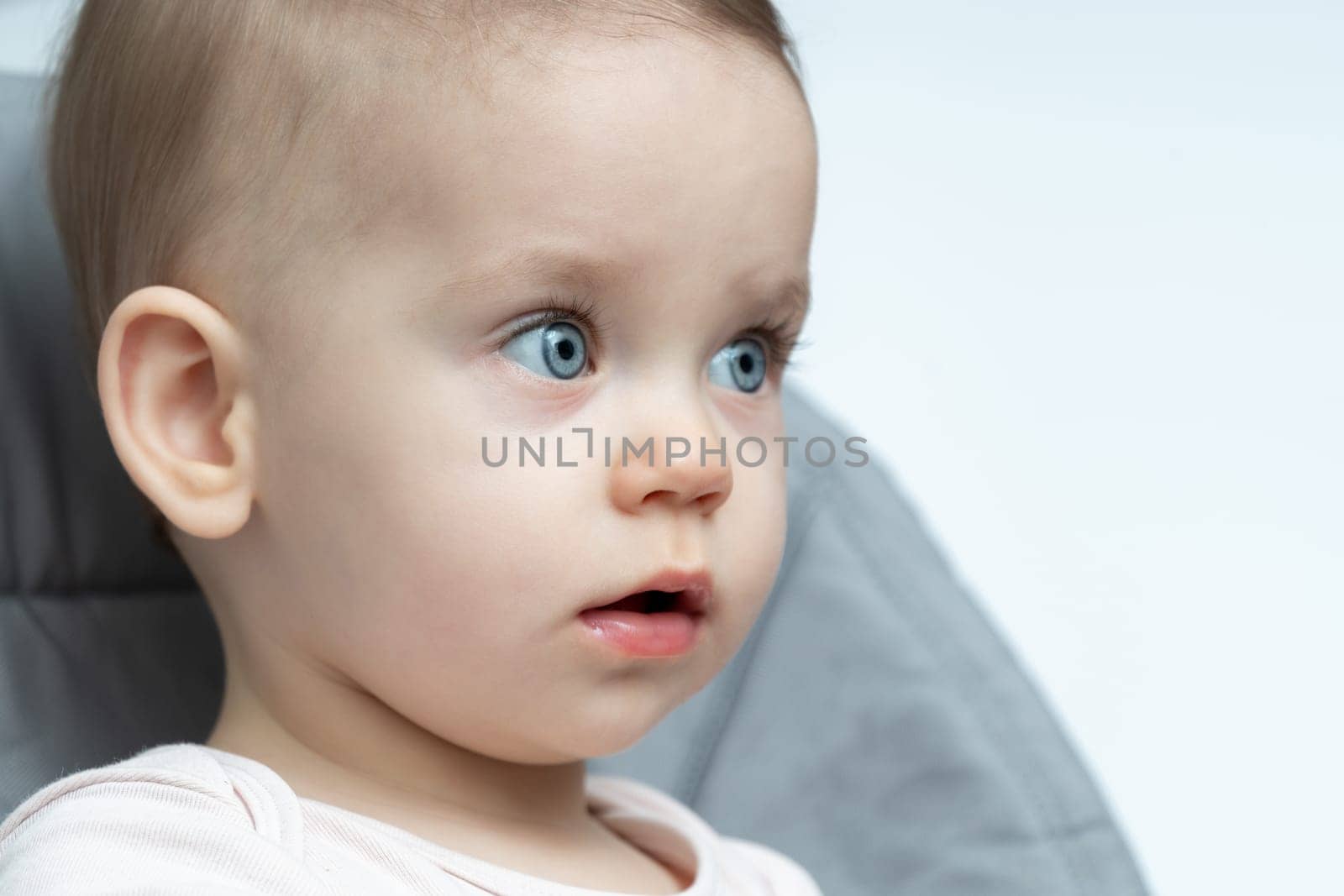 Adorable baby with bright blue eyes and curious expression