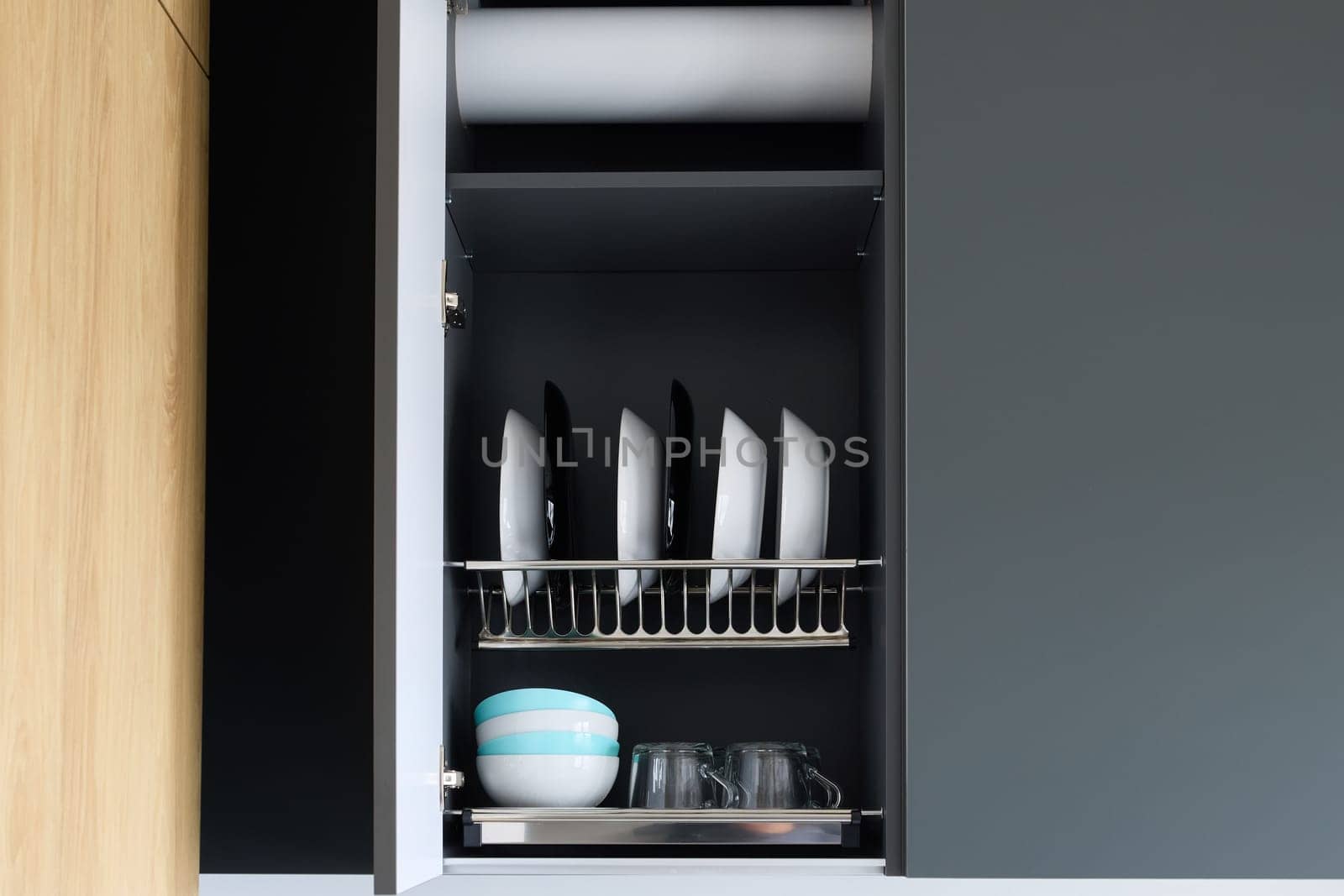 This contemporary kitchen cabinet beautifully showcases a neatly arranged collection of plates and glasses