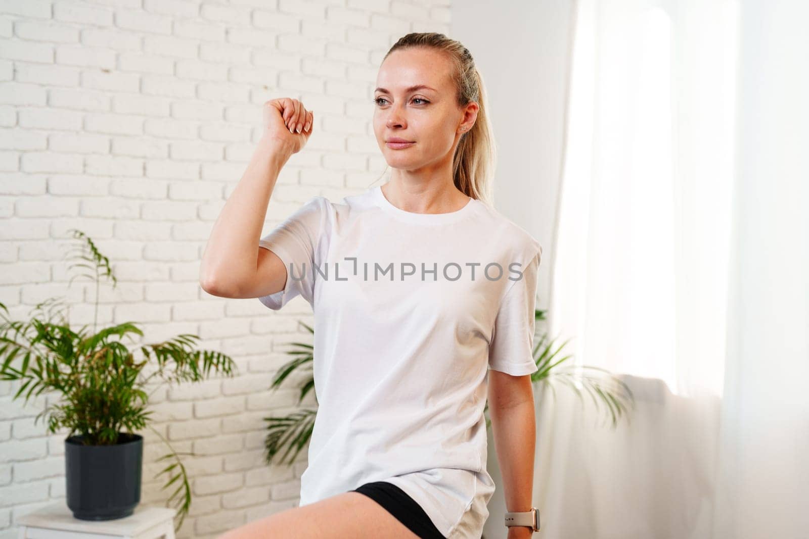 Woman performing a stretching exercise in a bright indoor fitness space