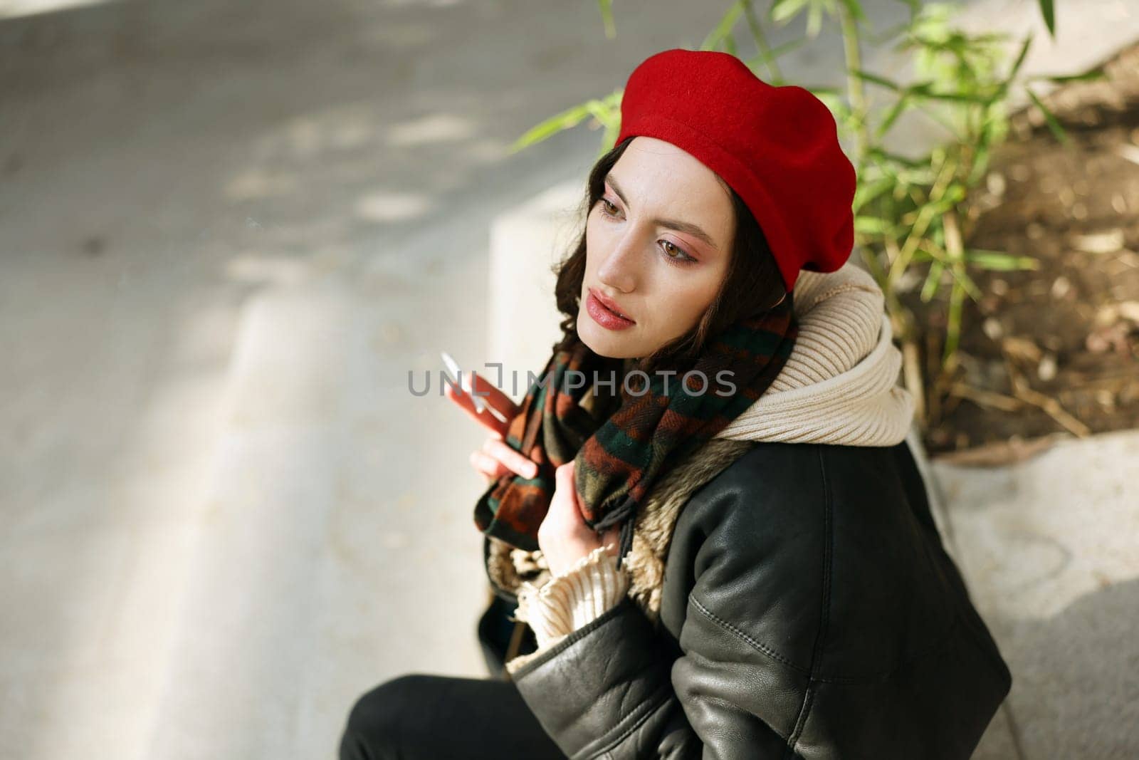 A young, stylish woman with a vibrant red beret and a chic leather jacket, radiating trendy urban fashion vibes