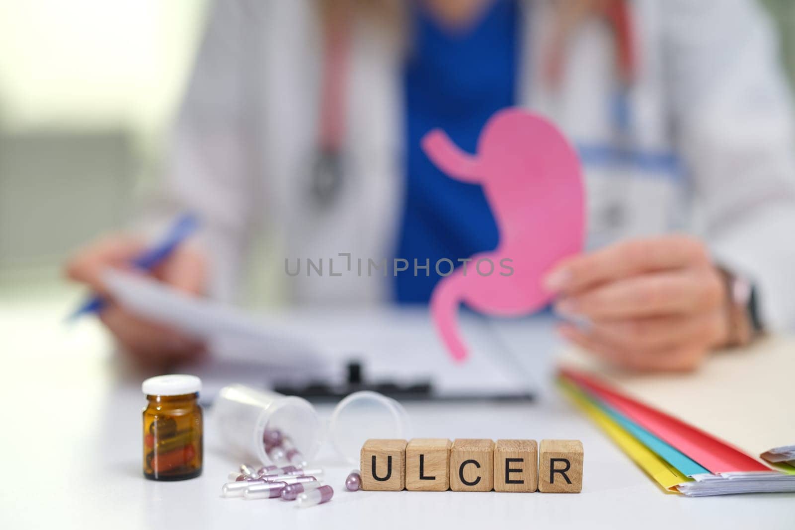 A knowledgeable doctor discusses stomach ulcers with a patient using informative visual aids and necessary medication