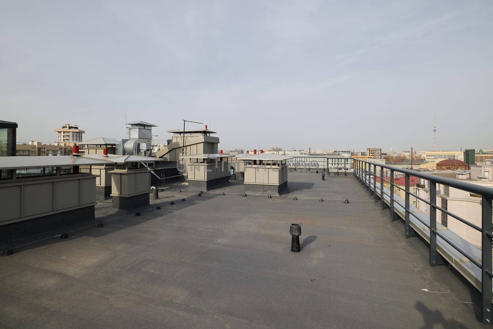 A captivating panoramic view of an urban rooftop featuring industrial structures and essential equipment