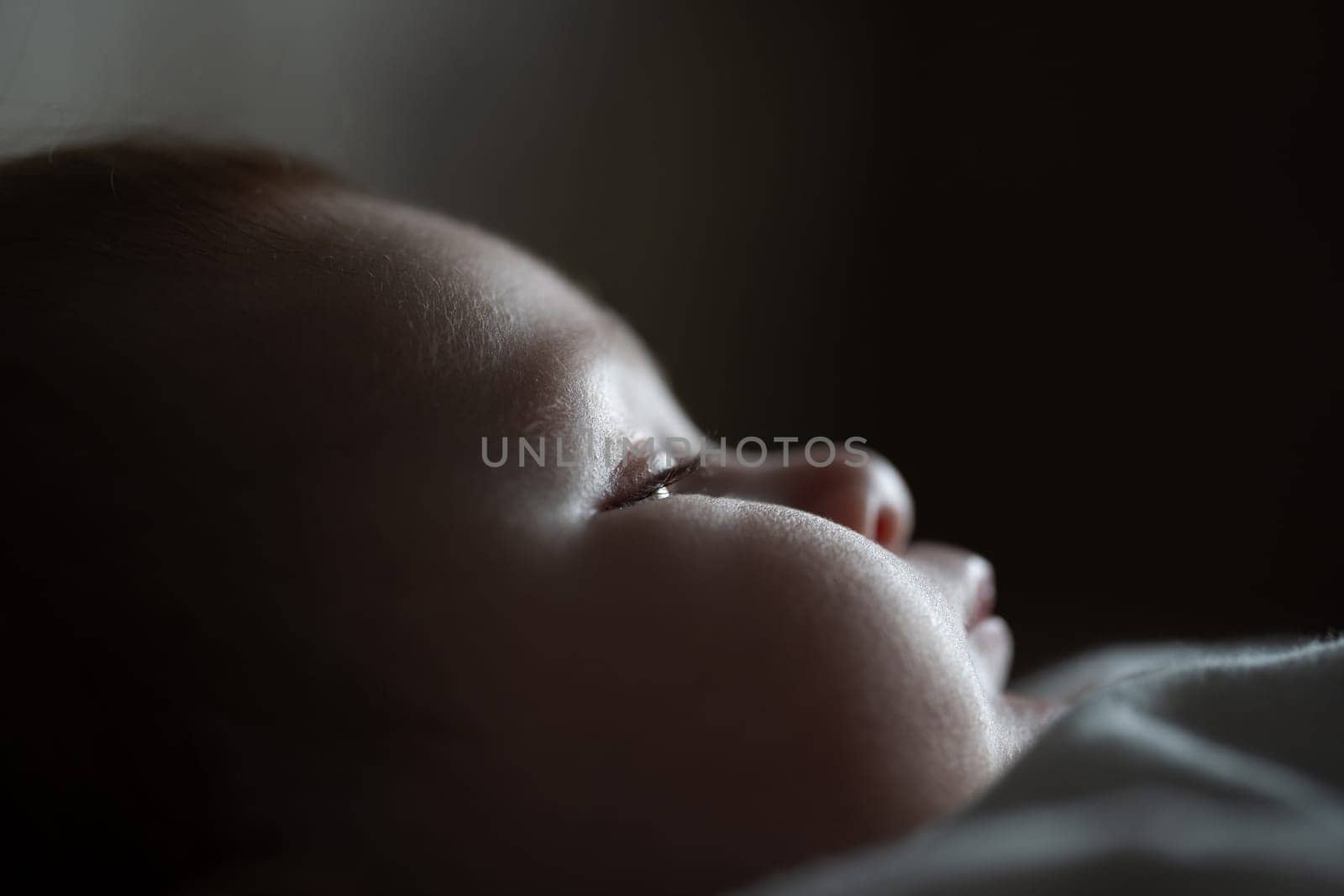 Macro close-up shot of a baby's eyes with eyelashes and chubby cheeks. Childhood and baby concept. High quality photo