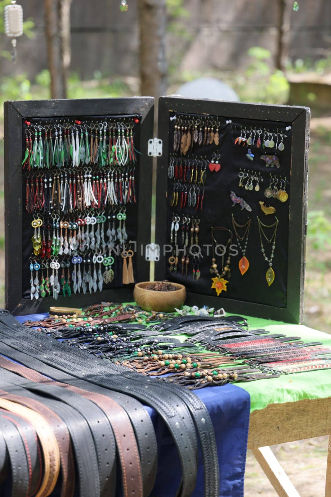 A vibrant and colorful array of unique handmade jewelry and stylish belts beautifully displayed at an outdoor market