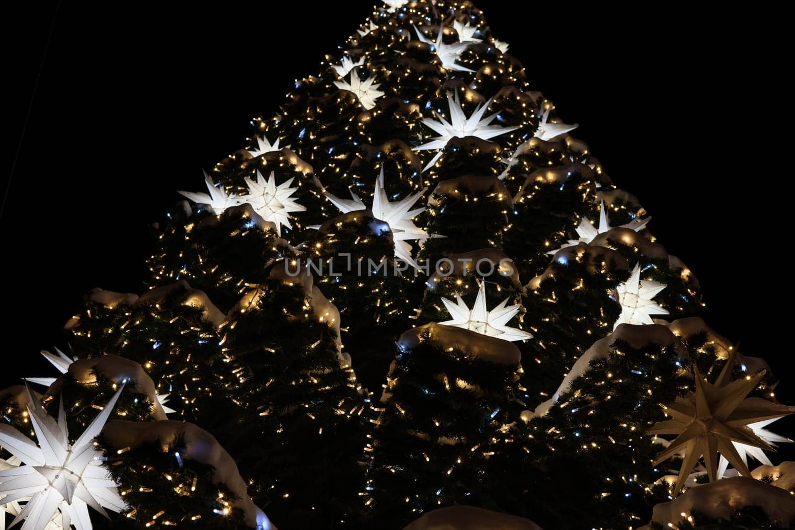 A beautifully decorated Christmas tree illuminated with stars and lights, creating a festive atmosphere.
