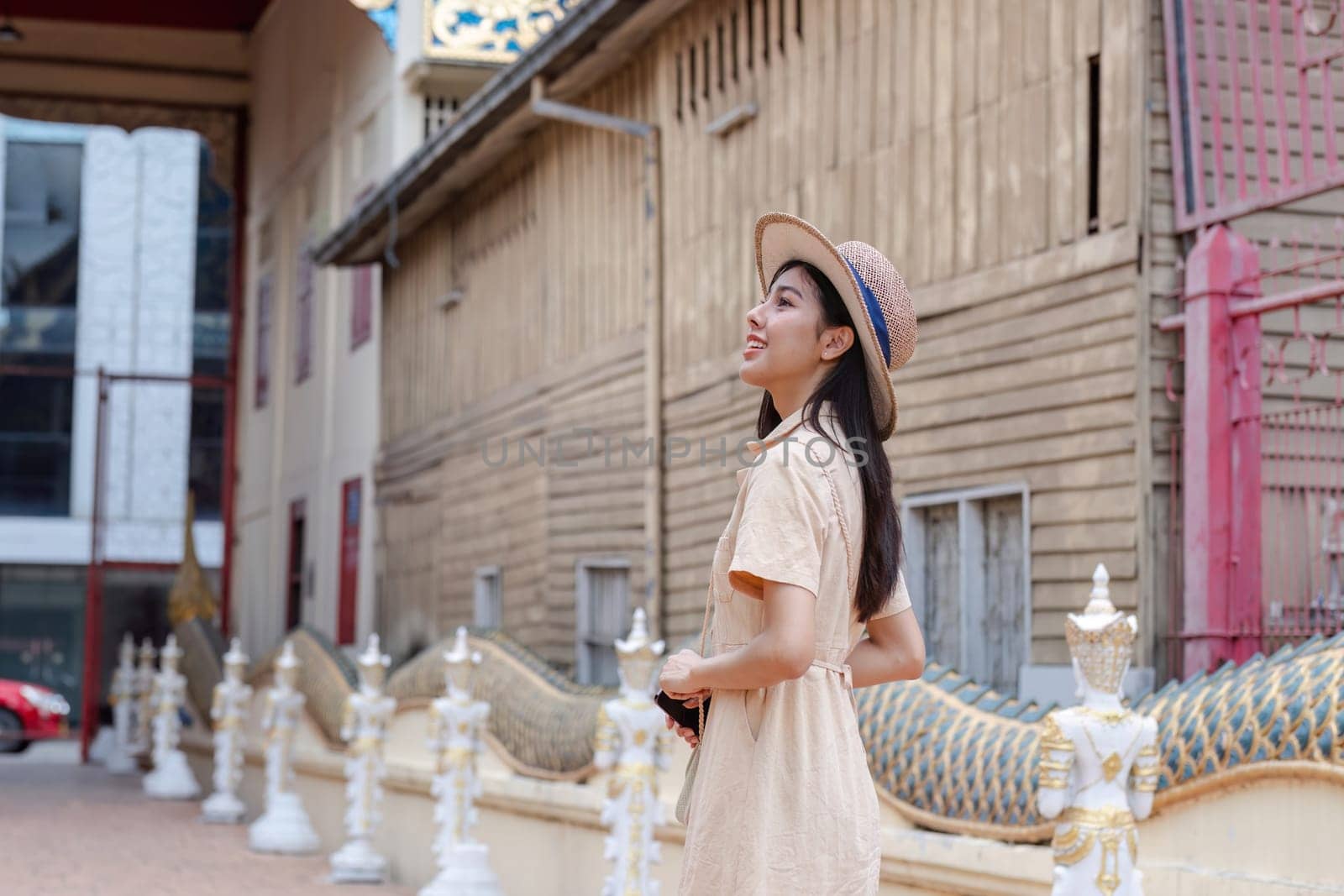 A young woman enjoys sightseeing in the city, taking in the urban architecture and cultural landmarks on a sunny day.