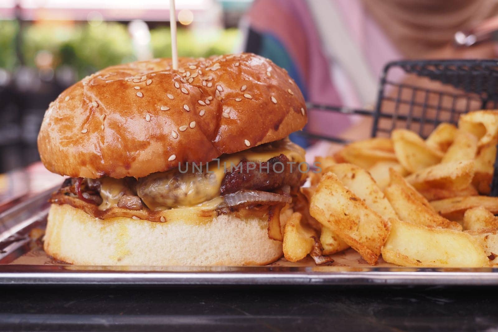 Cheeseburger With chips on a wooden table .