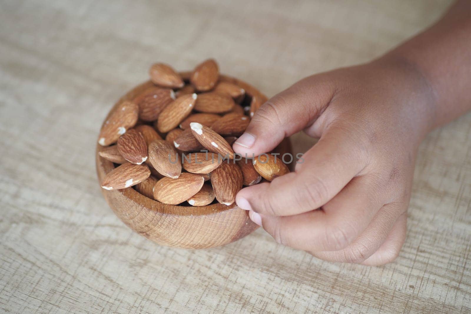 Close up of child hand pick almond nut .