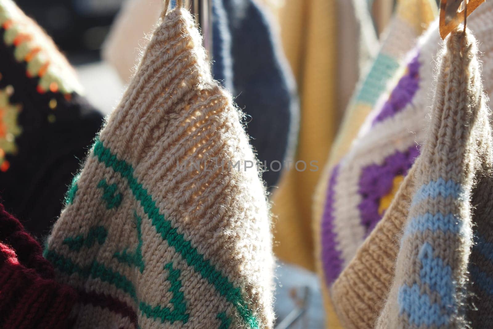 Vibrant hand-knit bags displayed, showcasing intricate designs and warm textures.
