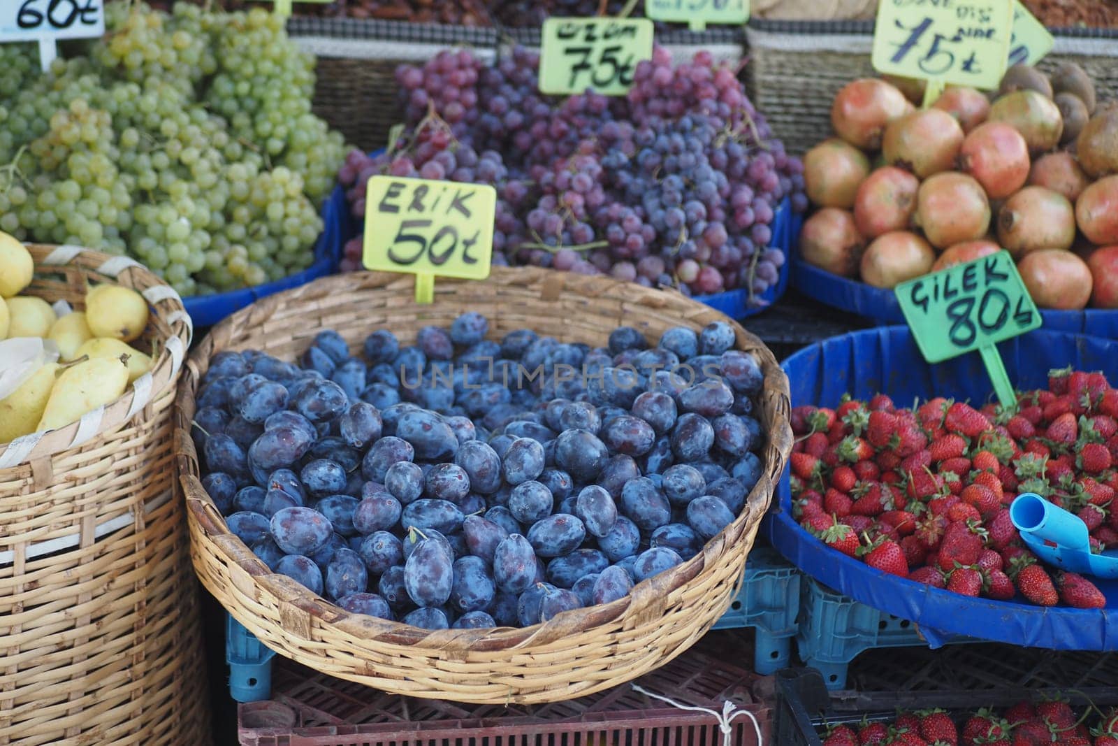 A vibrant display of fresh assorted fruits in various baskets at a bustling market