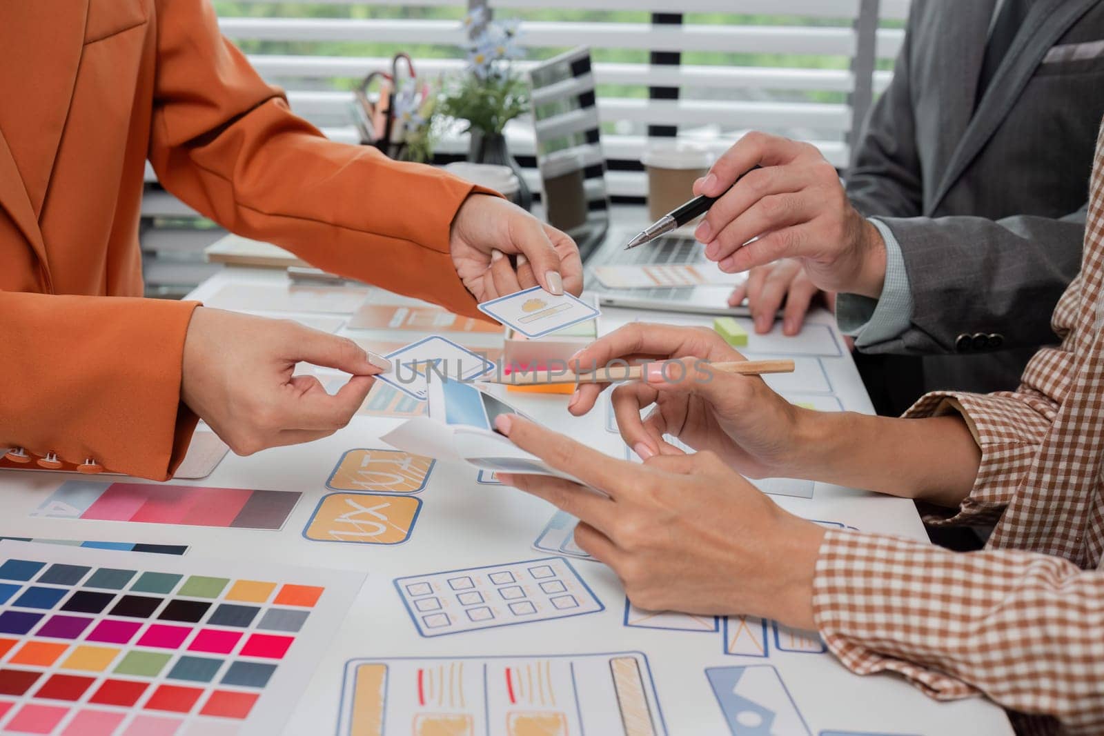 A dynamic team of graphic designers working together on creative projects, sharing ideas and designs in a modern office setting.