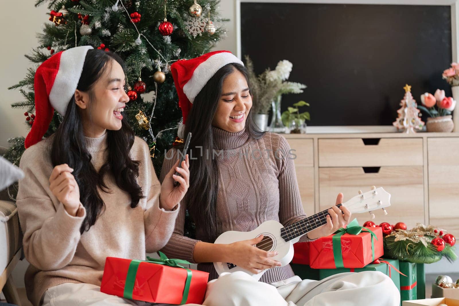 A young couple enjoys a cozy Christmas party at home, surrounded by festive decorations and gifts.