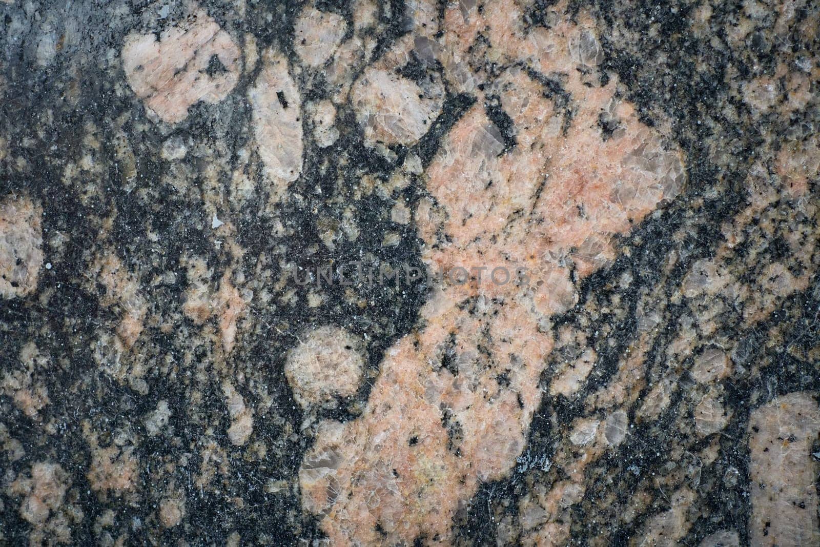 Close-up view of polished granite surface revealing intricate patterns and mineral composition, ideal for backgrounds or design projects.