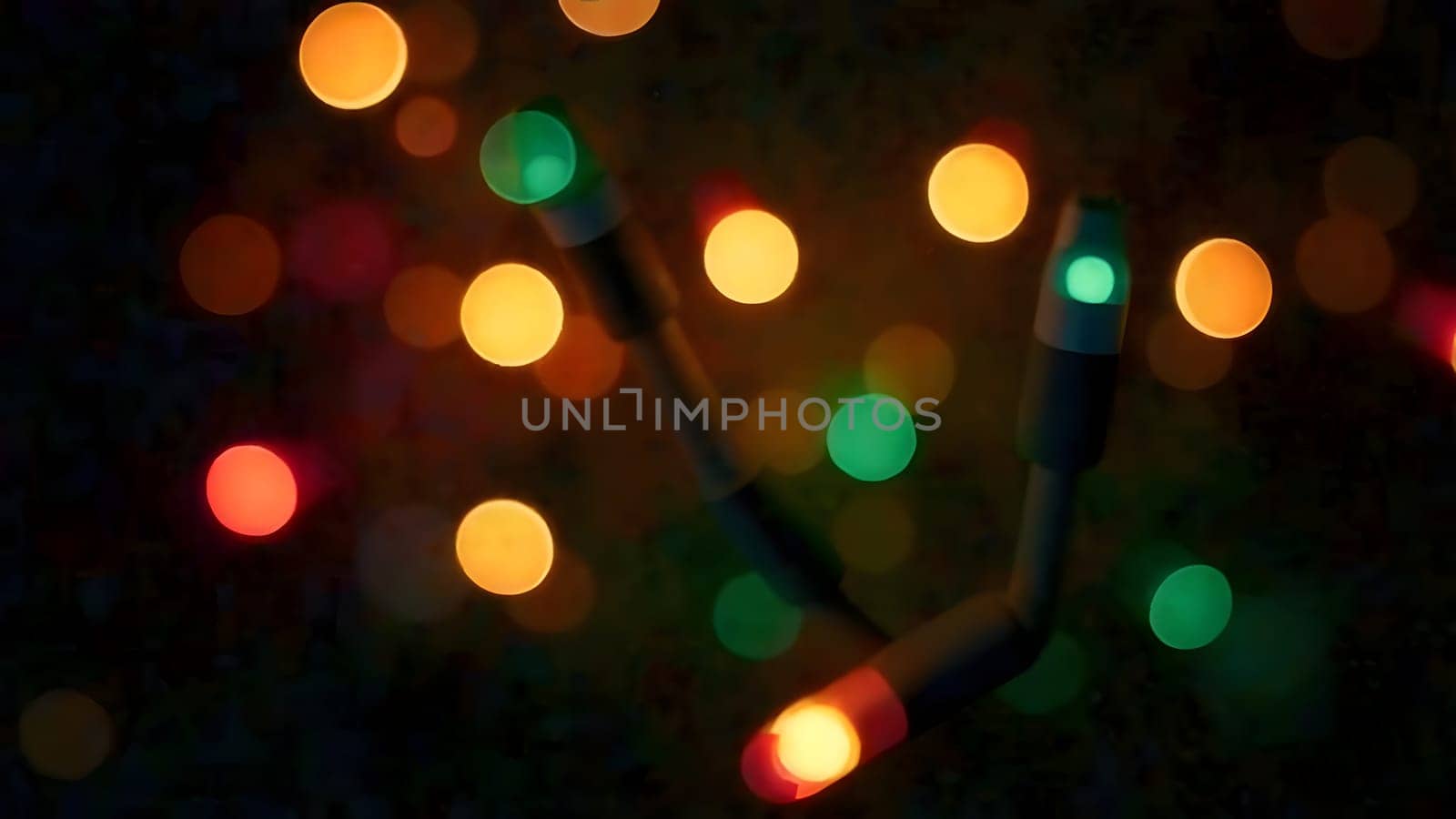 Glowing Christmas lights gently shift colors in a seamless loop, their soft flickers creating a warm and inviting holiday ambiance on a blurred background.