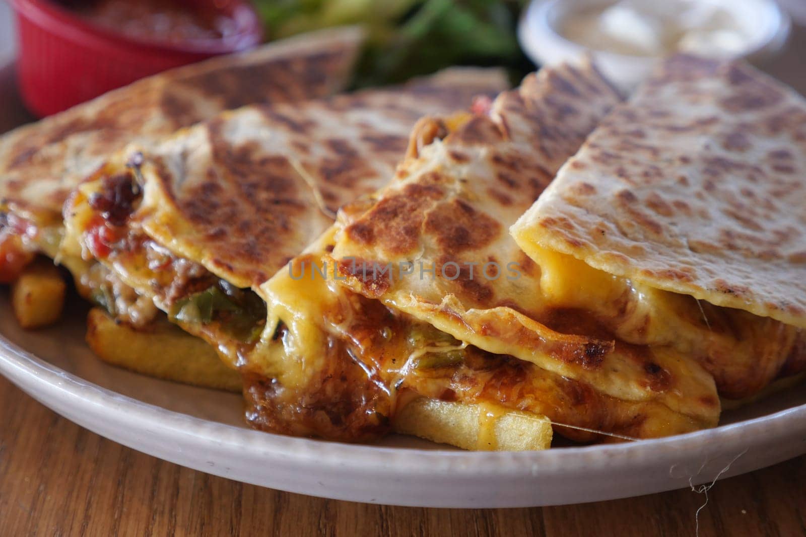 Tasty quesadillas served with various dipping sauces and garnishes enhance your meal