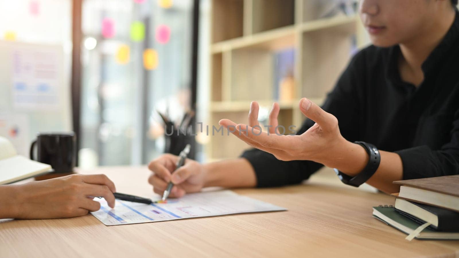 Close up of business colleagues exchange ideas and analyzing data during a meeting.
