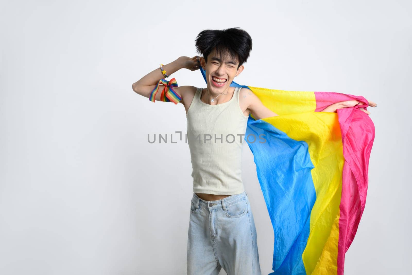 Cheerful man waving pansexual pride flag with excitement and joy to celebrating diversity and acceptance.