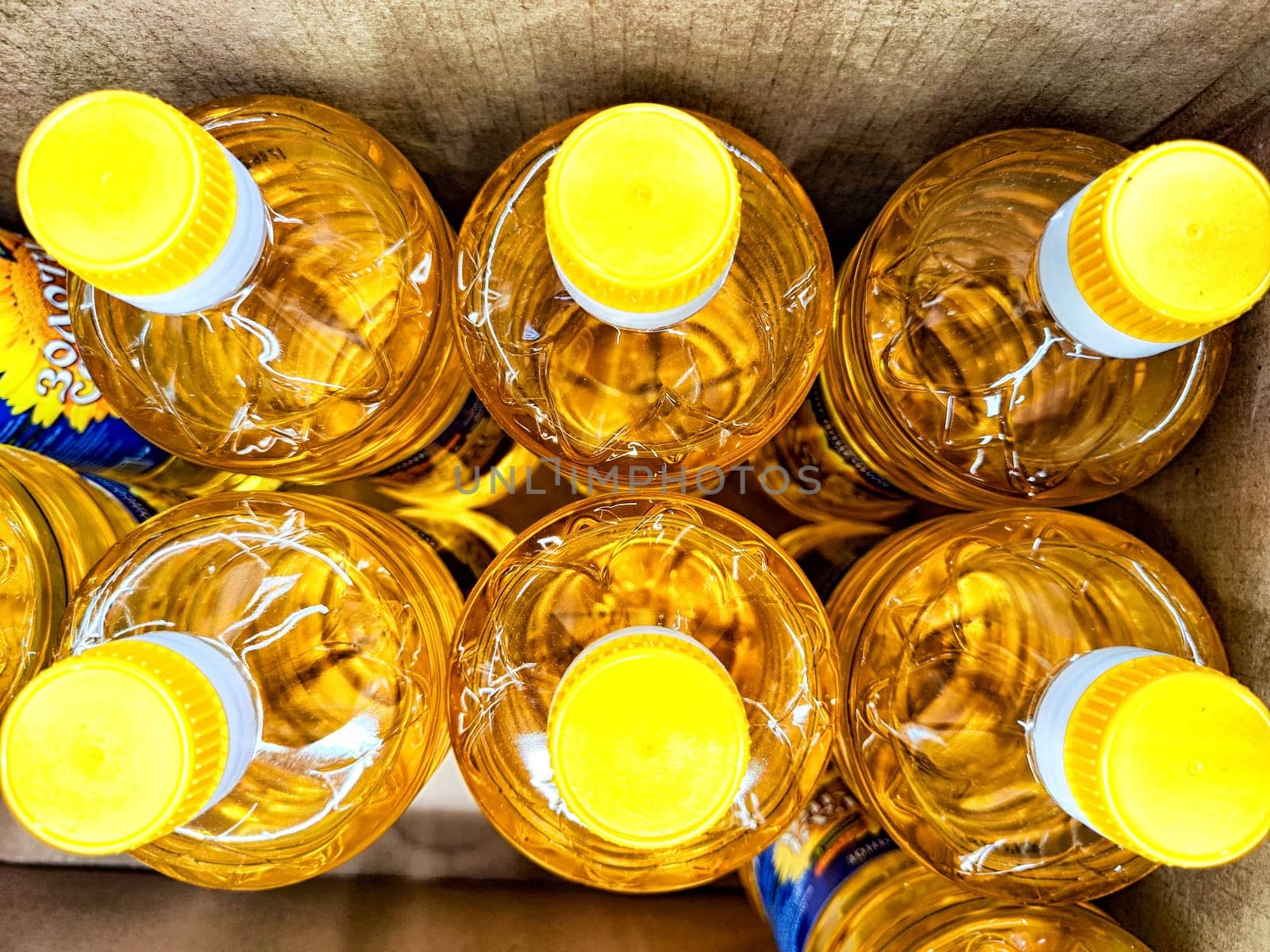 Several bright yellow bottles with caps are organized in a cardboard box, showcasing a vibrant arrangement ideal for beverage storage.