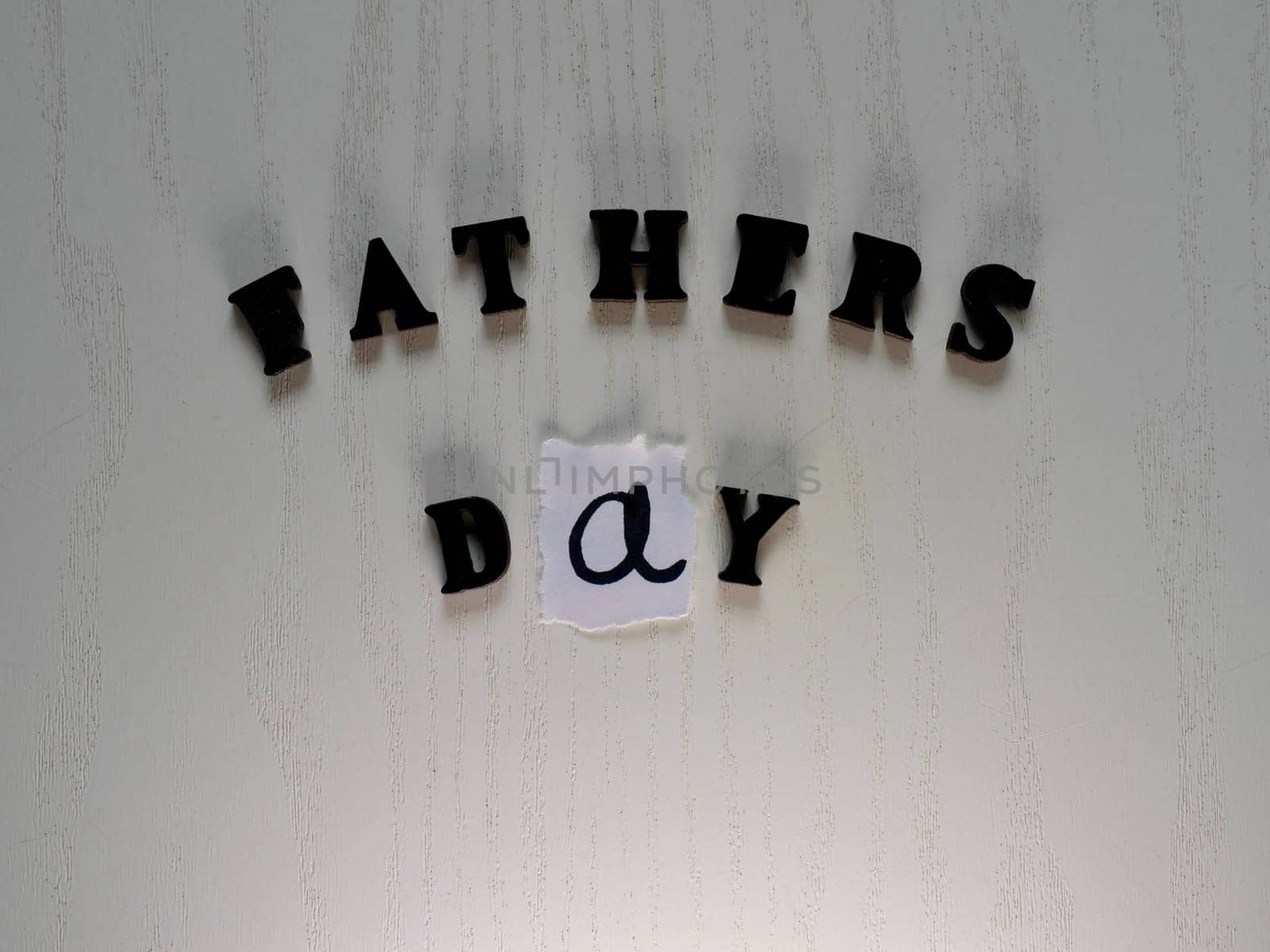 Lettering father in black letters on grey background on father's day close-up