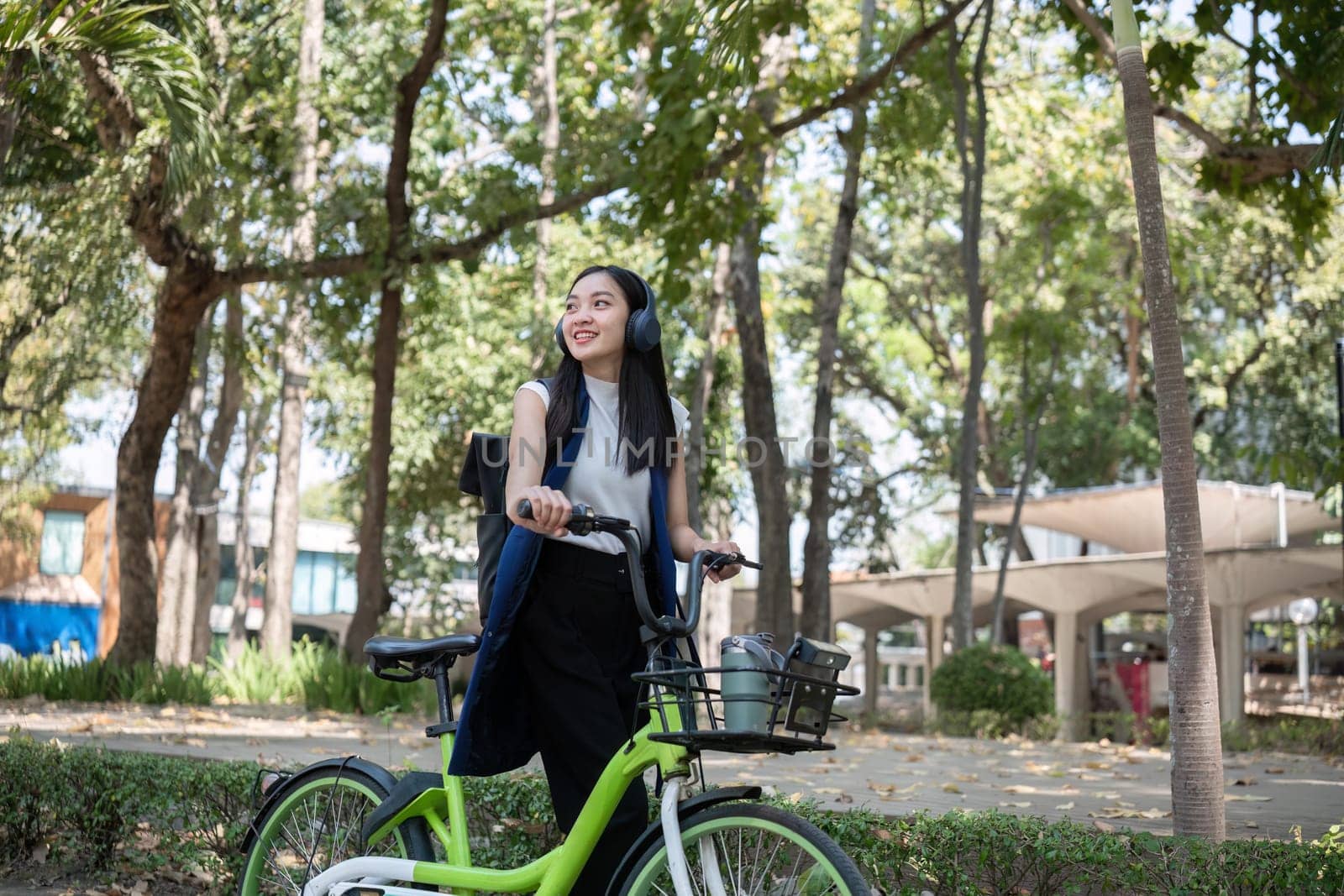 A young woman enjoys a bicycle ride in a park championing clean energy and pollution reduction for a healthier planet.
