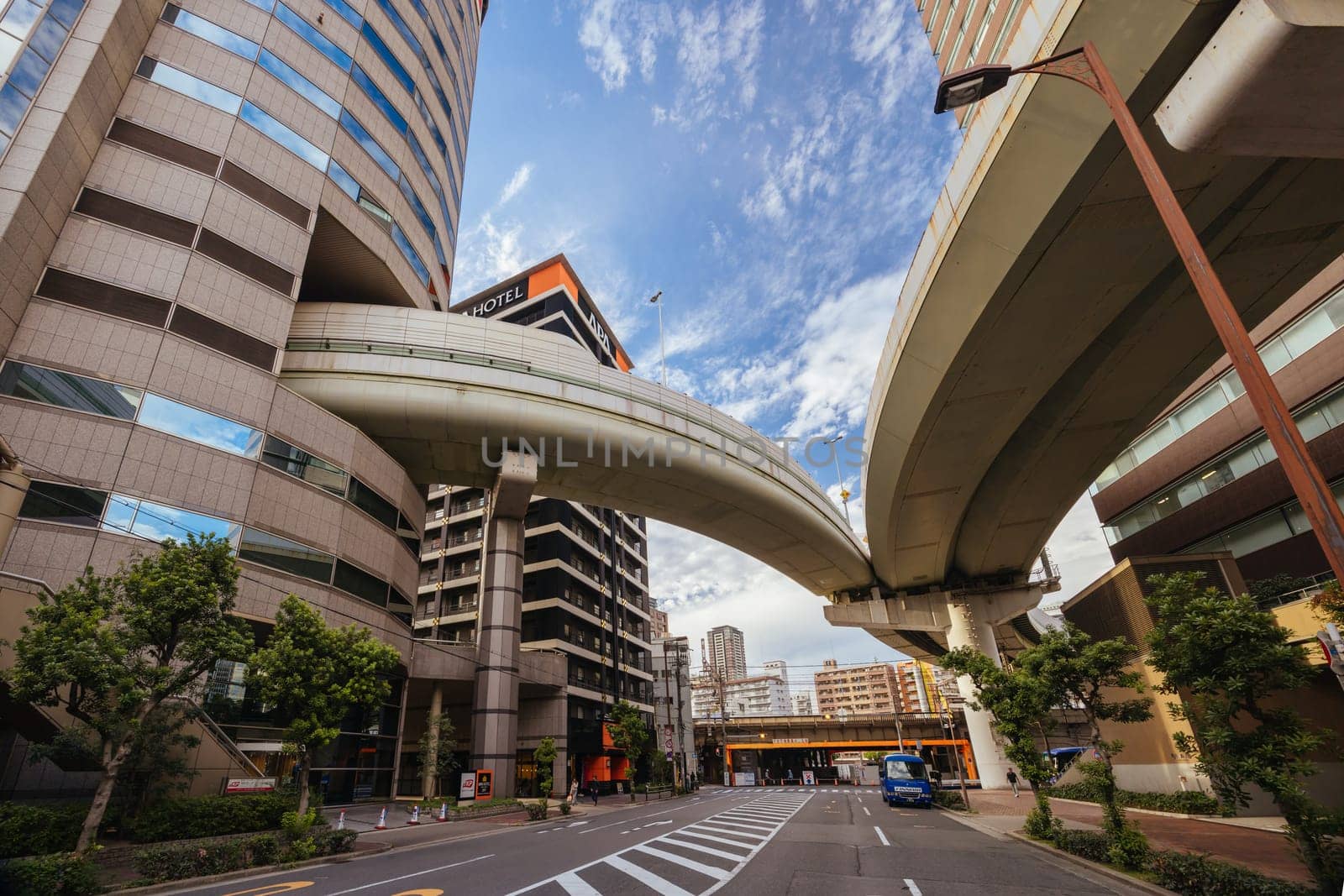 OSAKA, JAPAN - SEPTEMBER 25 2024: The famous 'highway thru a building'. The off ramp for the Umeda Exit of the Ikeda Route of the Hanshin Expressway going thru the Gate Tower Building in Downtown Osaka, Japan