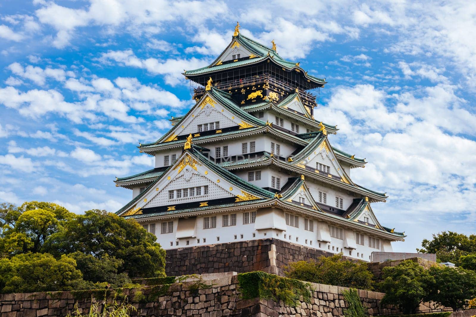 OSAKA, JAPAN - SEPTEMBER 25 2024: The iconic Osaka Castle and lush surrounds on a warm clear autumn day in Osaka, Japan on September 25th 2024