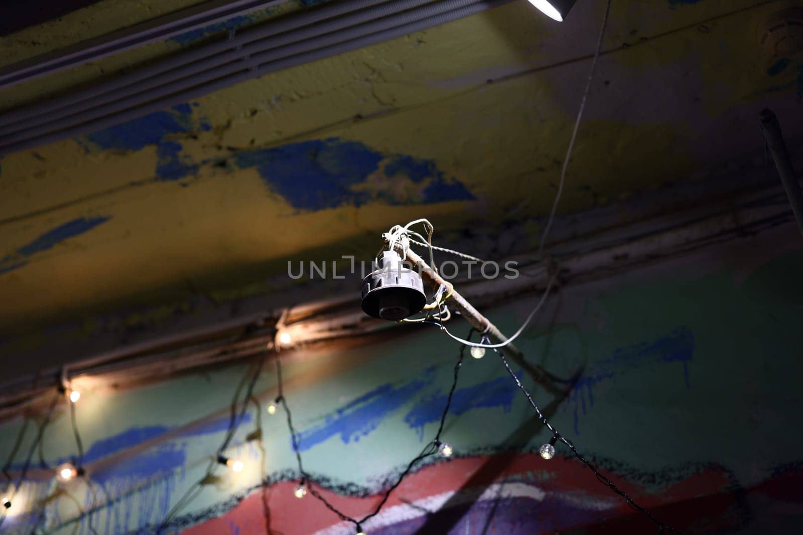 An elegant artistic light fixture hangs beautifully against a uniquely textured wall, creating a stunning ambiance