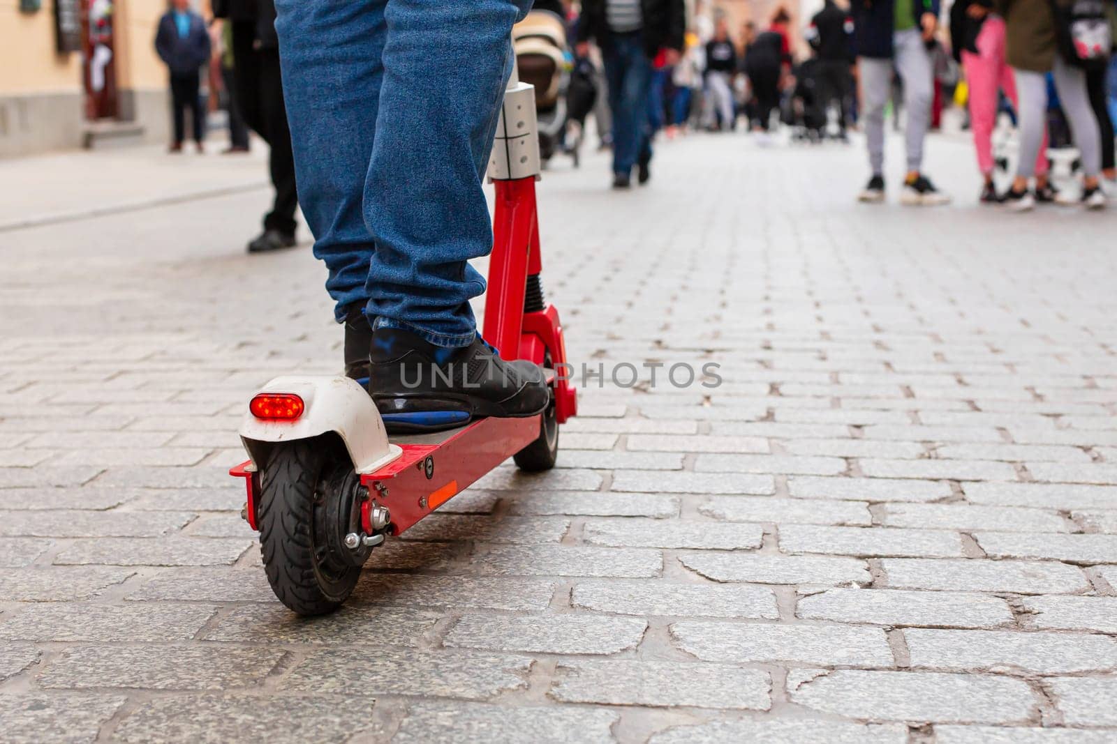 A man is driving along the touristy old streets of Europe