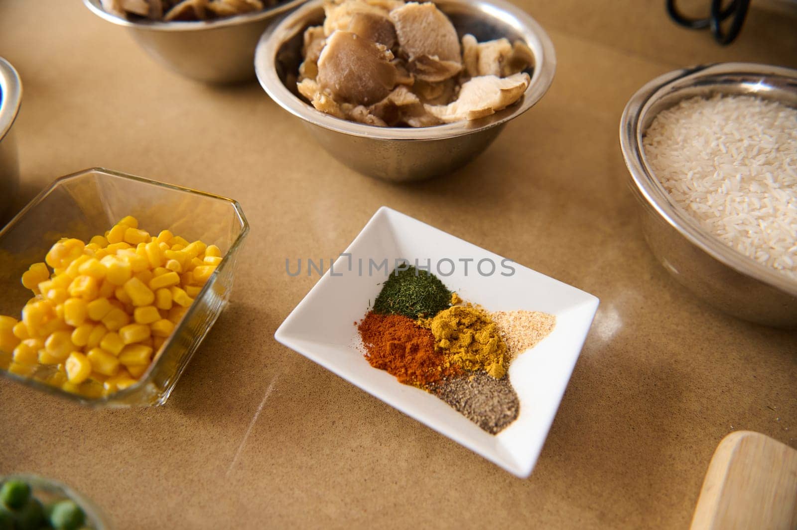 An assortment of fresh and dry ingredients arranged for cooking vegetarian paella, including colorful spices, vegetables, and rice. A perfect representation of creativity in the kitchen.