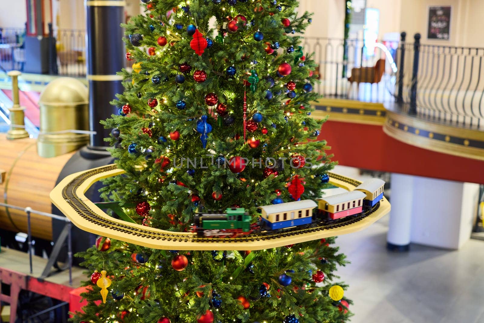 A beautifully decorated and sparkling Christmas tree featuring a delightful toy train along with colorful ornaments