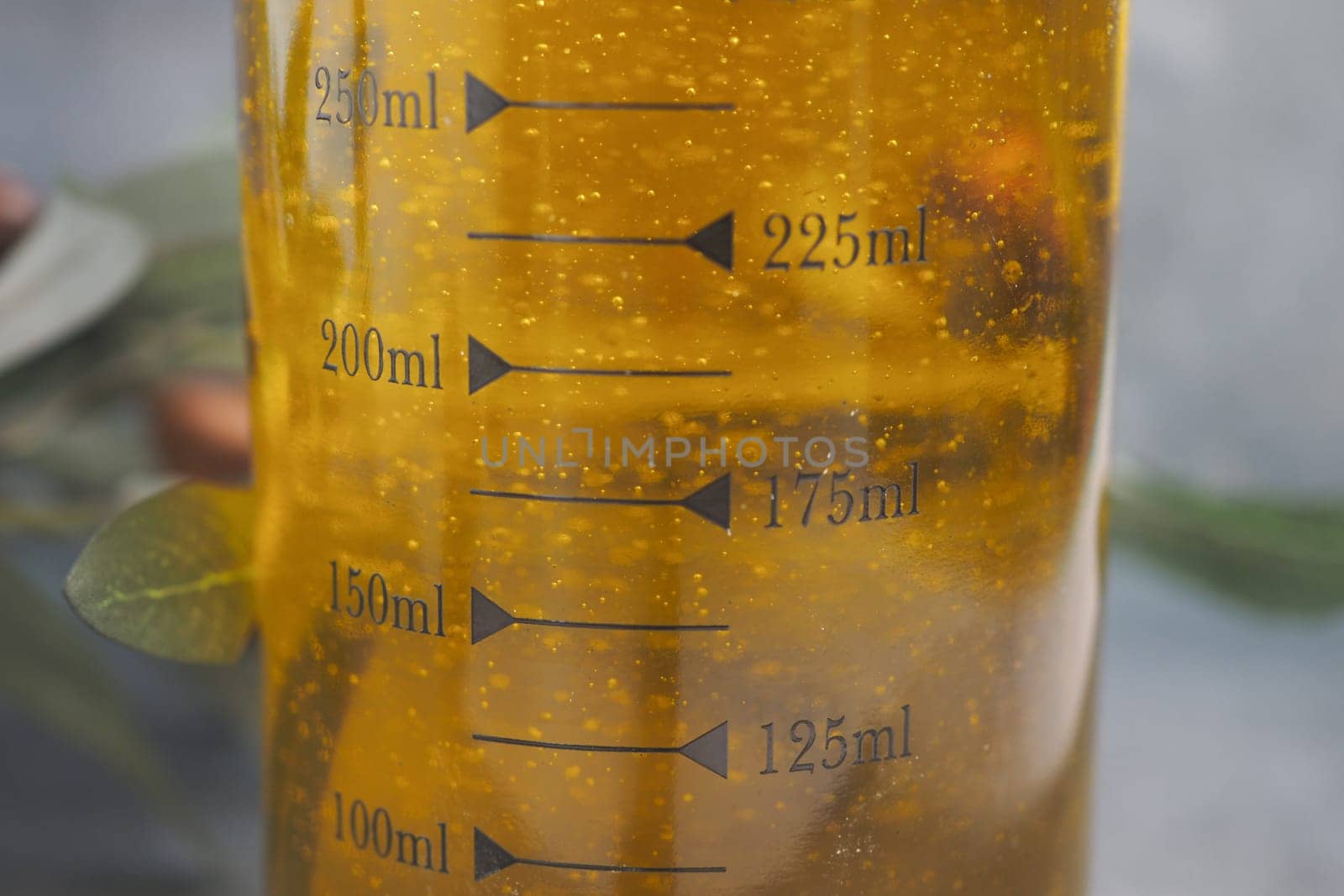 A closeup shows oil in a measuring jug with clear markings for easy cooking or baking