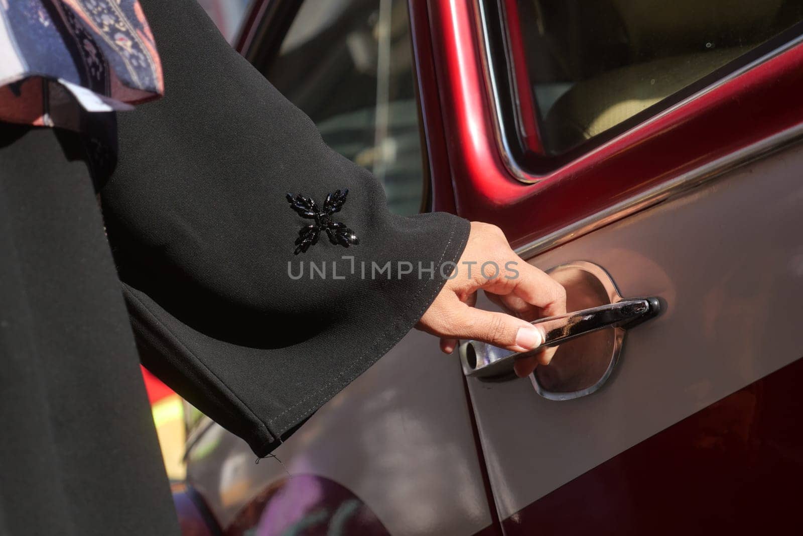 A hand reaching for a classic car door handle, showcasing a moment of anticipation.