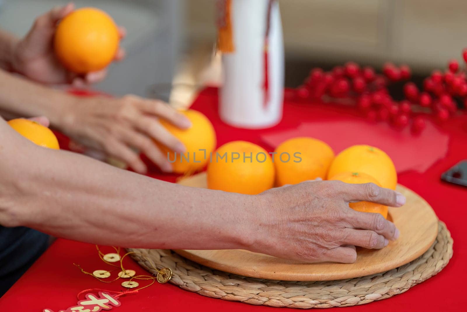 An elderly Chinese couple joyfully prepares oranges for Chinese New Year embracing tradition and warmth in their home.