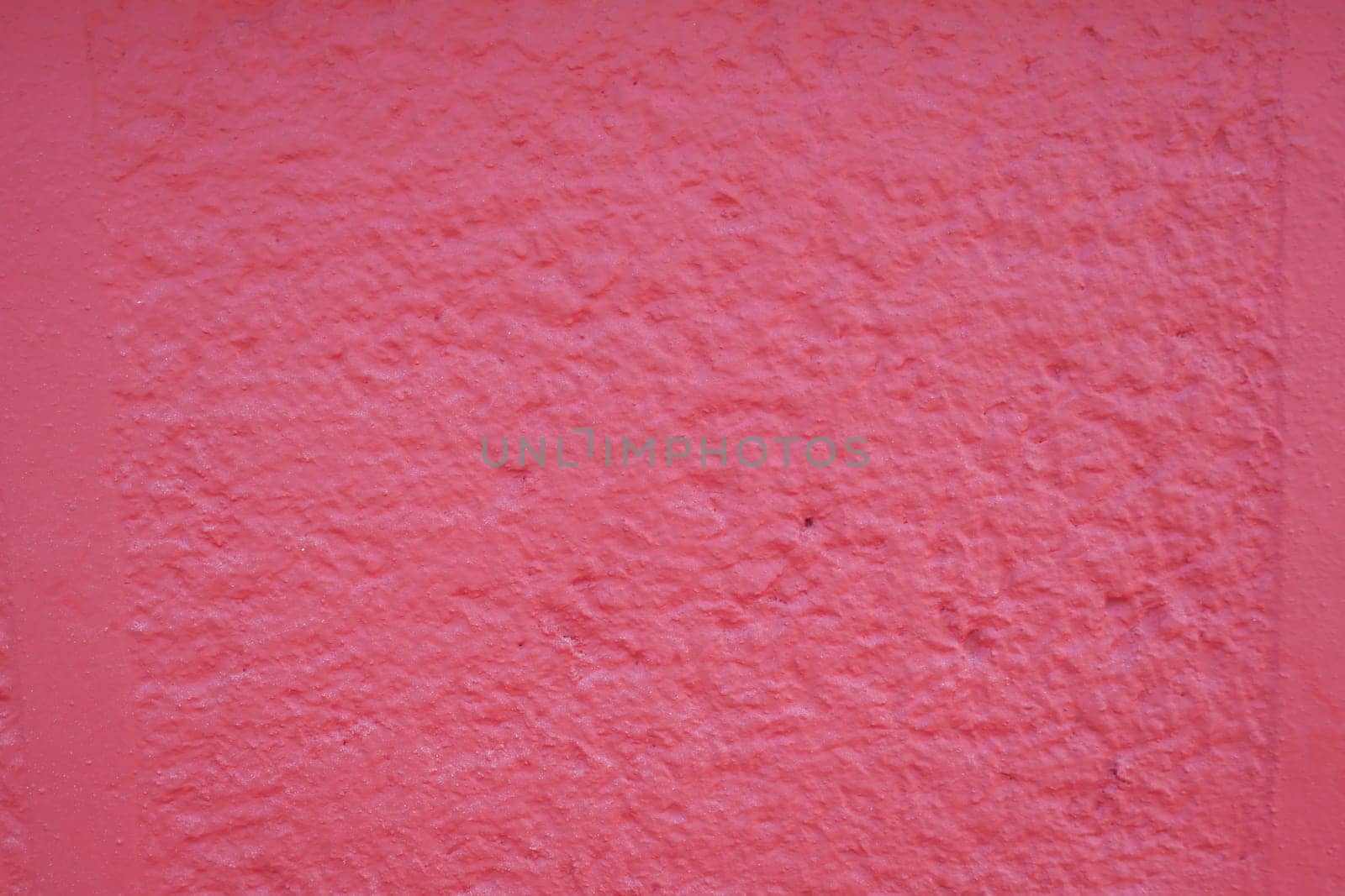 A vibrant pink wall with a textured, rough surface for dynamic, captivating visuals