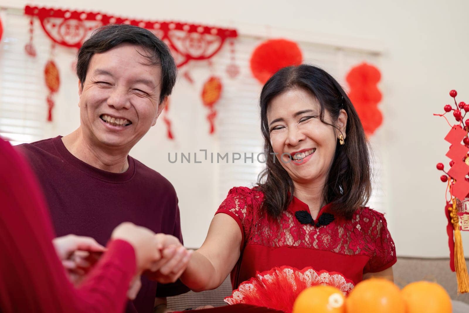 A joyous family gathering celebrating Chinese New Year highlighting the love between grandparents and their granddaughter.
