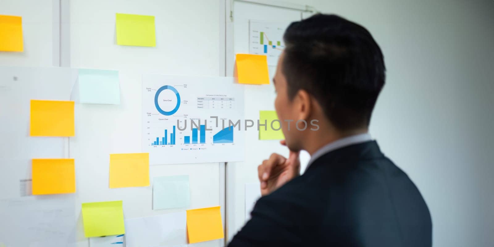 Businessman brainstorming with creative idea working for strategy and planning. Female writing ideas on sticky note for reminder or startup new project.