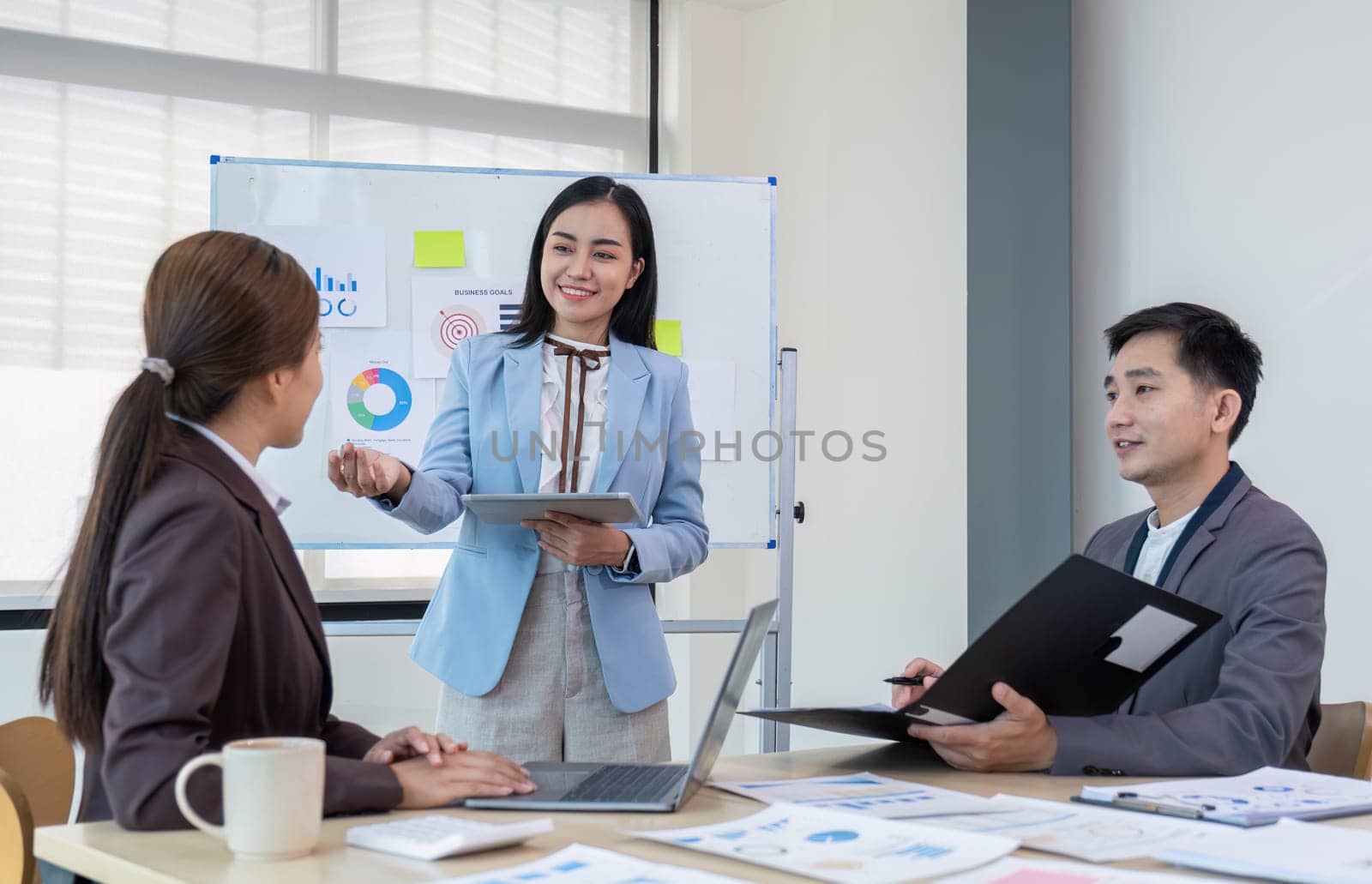 Business People Meeting using laptop computer,calculator,notebook,stock market chart paper for analysis Plans to improve quality next month. Conference Discussion Corporate Concept. by wichayada