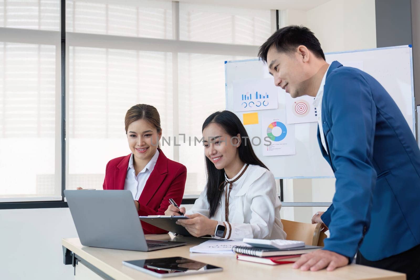 Business People Meeting using laptop computer,calculator,notebook,stock market chart paper for analysis Plans to improve quality next month. Conference Discussion Corporate Concept..