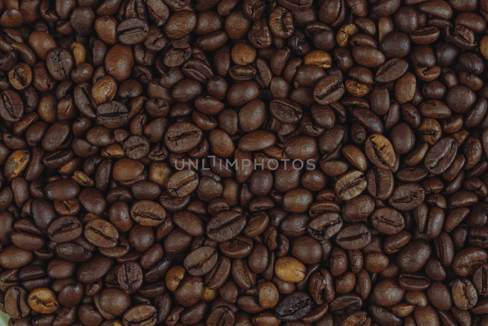 A detailed close-up view of roasted coffee beans forming a textured background, ideal for coffee-related designs and concepts.
