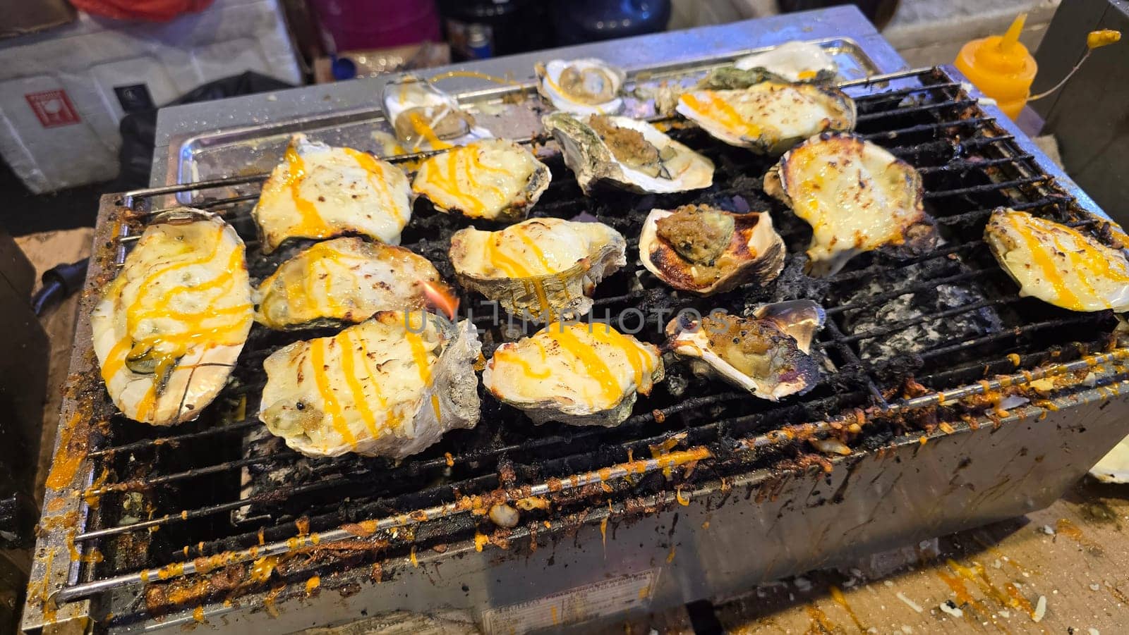 street vendor uses a torch flame to prepare delicious grilled oyster with flair and skill, showcasing the vibrant atmosphere of bustling night Thai markets. Good for recipe book