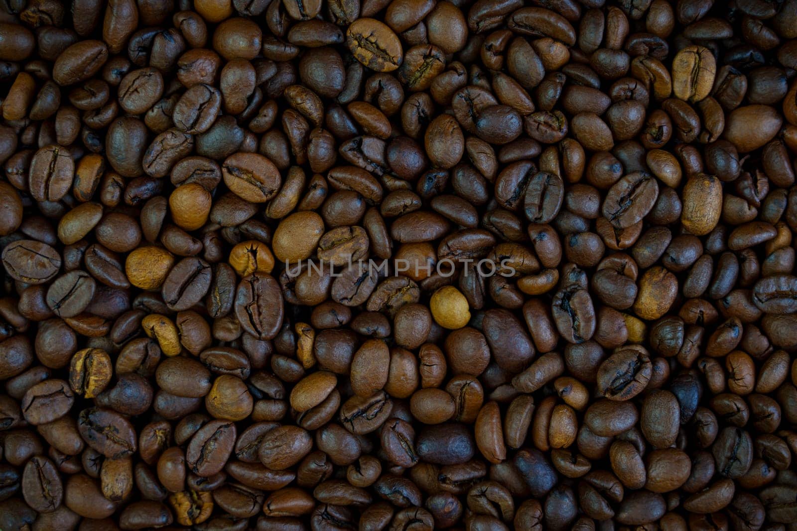 Detailed close-up of roasted coffee beans showcasing rich brown tones and natural textures, perfect for culinary and beverage concepts, no people.