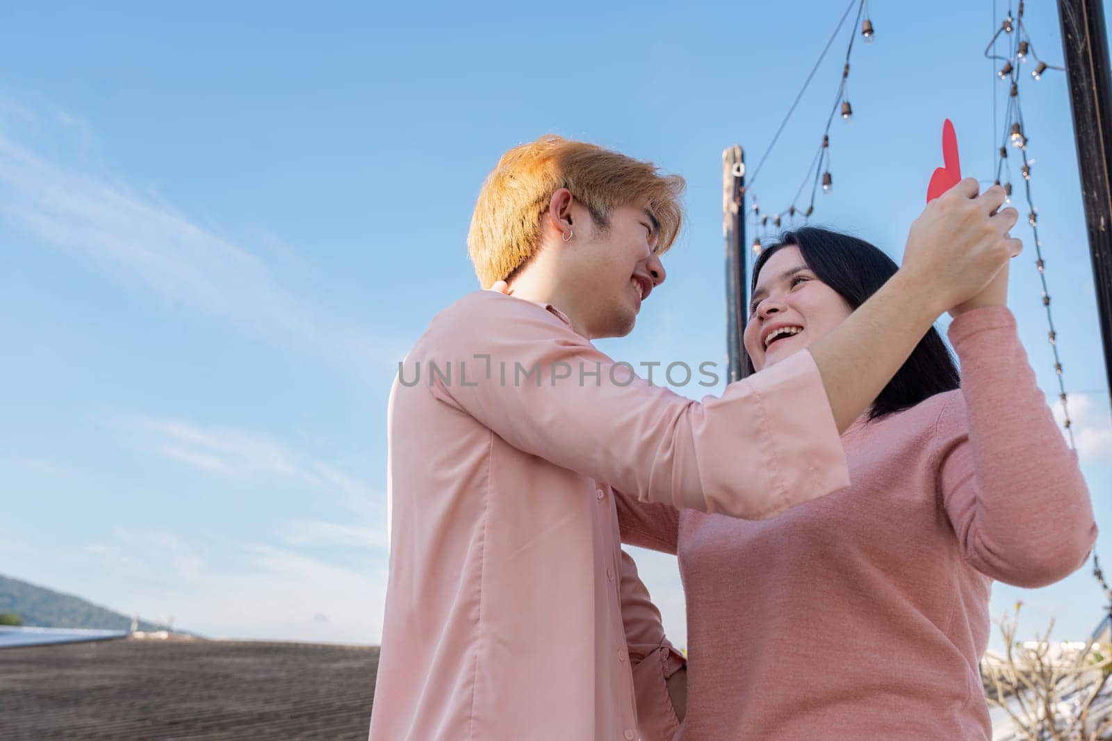 A joyful couple celebrates Valentine Day in a beautiful outdoor setting embracing love and connection.