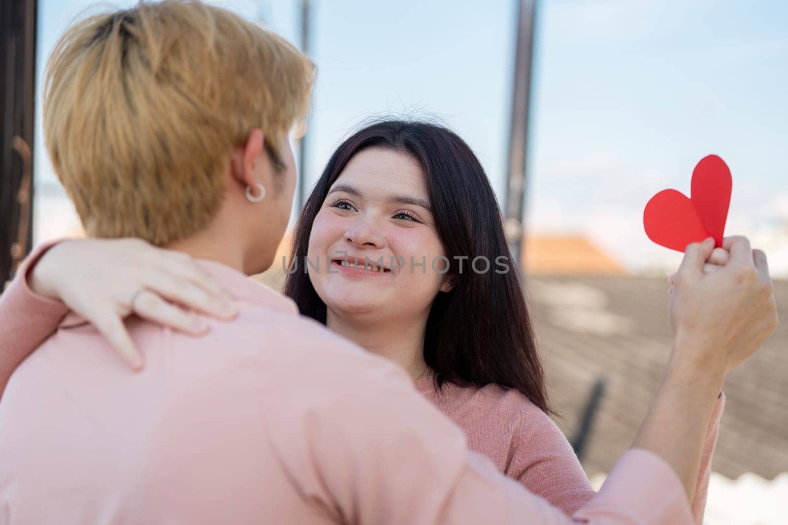 A couple joyfully celebrates Valentine Day outdoors sharing love and happiness in a picturesque setting.