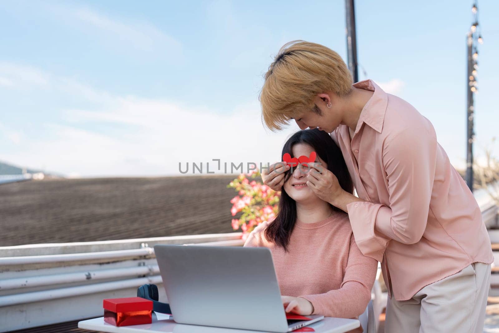 A couple shares a sweet moment at their beachside workspace with playful surprises embodying the spirit of Valentine Day.
