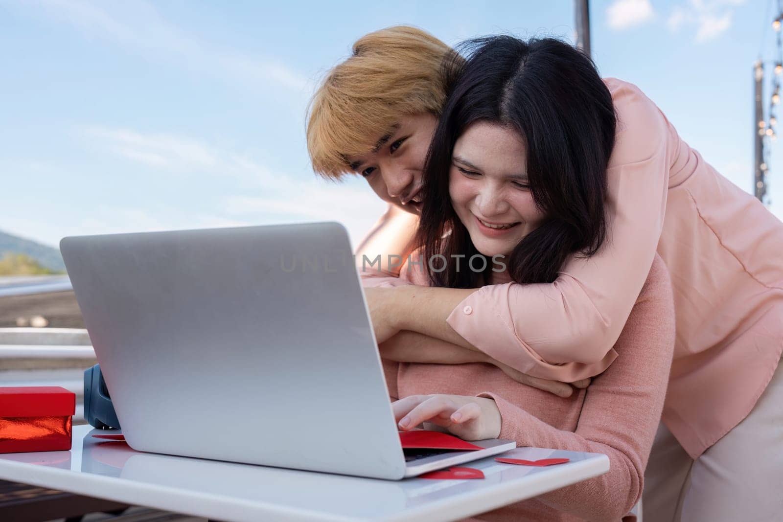 A couple joyously shares a moment together embracing love and technology while celebrating Valentine Day.