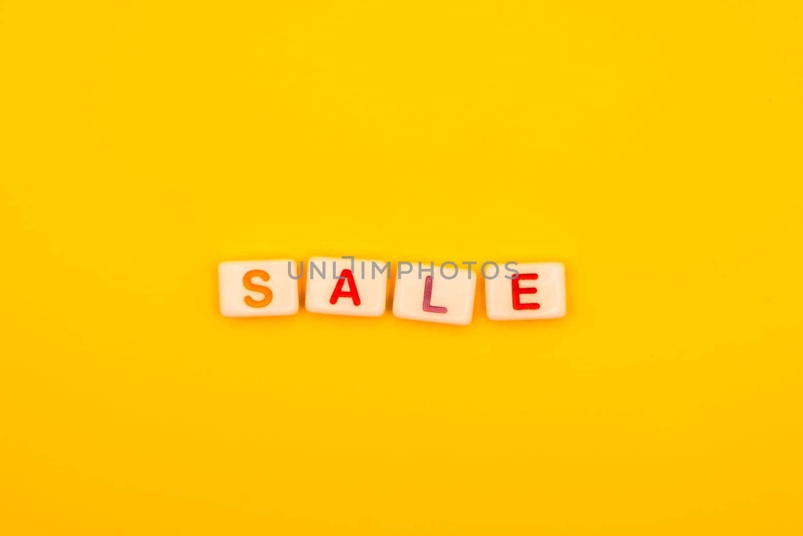 Vibrant letters spelling "Sale" on a bright yellow background, perfect for promotional visuals, advertising, and marketing campaigns for discounts and offers.