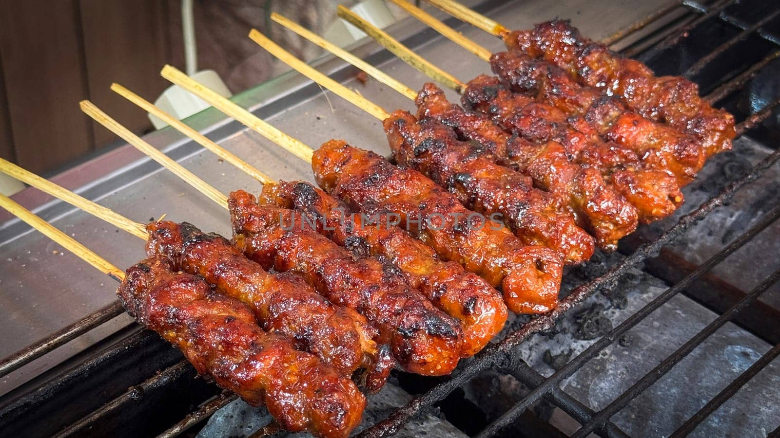 skewered beef meat on a grill, or barbecue bbq, locals called it beef satay showcasing their vibrant glaze and texture. Perfect representation of barbecue culture, grilling cuisine, and outdoor cooking enjoyment.