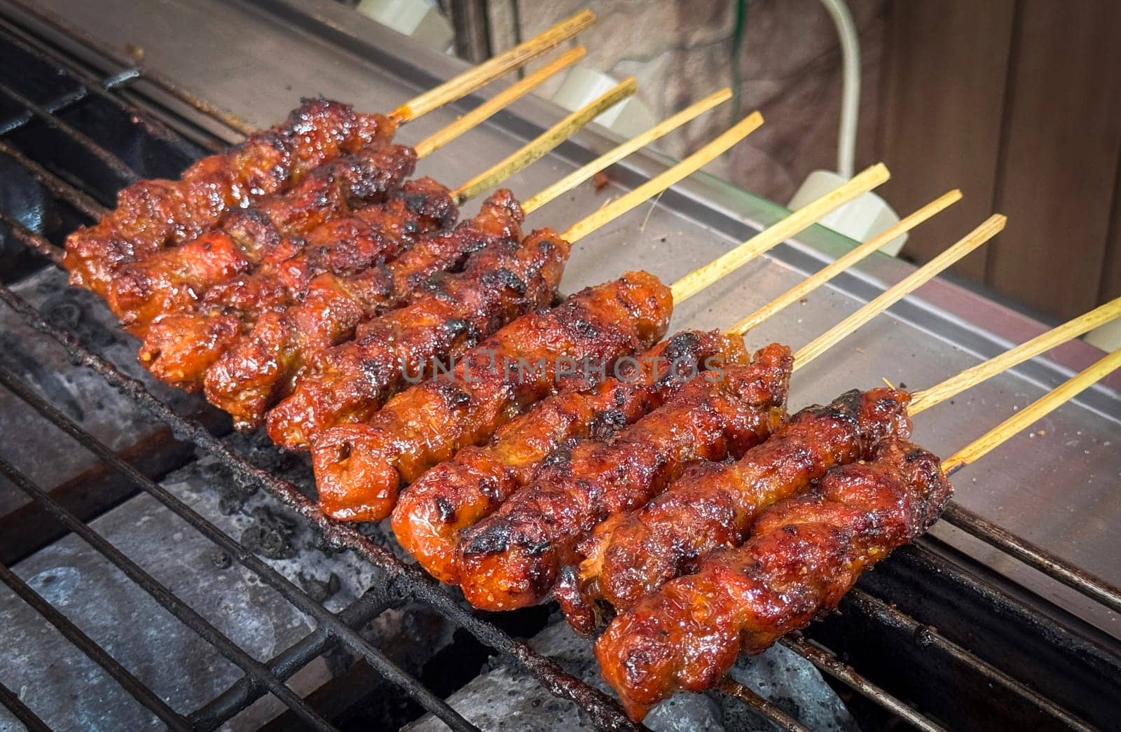 skewered beef meat on a grill, or barbecue bbq, locals called it beef satay showcasing their vibrant glaze and texture. Perfect representation of barbecue culture, grilling cuisine, and outdoor cooking enjoyment.